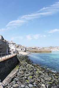 Scenic view of sea by buildings against sky