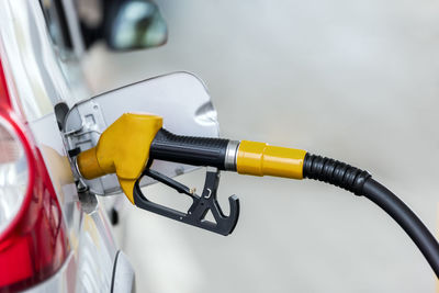 Silver car refuelling at the gas station, the concept of fuel energy