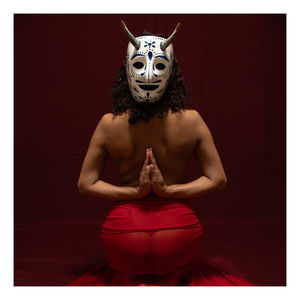 Portrait of woman wearing mask against black background