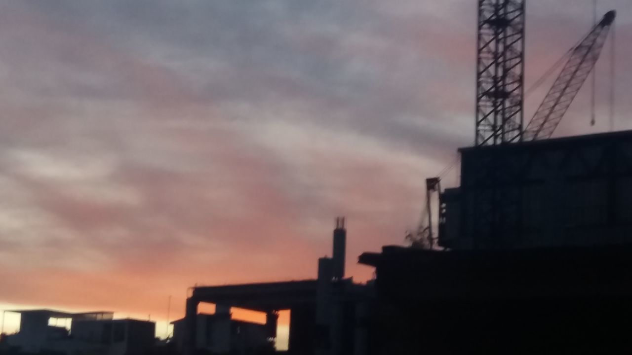 LOW ANGLE VIEW OF BUILDINGS AGAINST CLOUDY SKY AT SUNSET