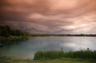 Scenic view of lake against cloudy sky