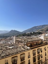 High angle view of buildings in city against clear blue sky