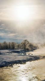 Scenic view of lake against sky during winter