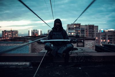 Man in city against sky at dusk