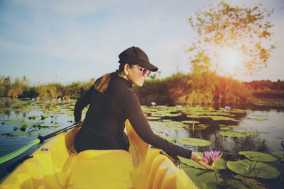 Side view of woman sitting on boat in lake