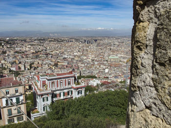 Aerial view of town by tree mountain against sky