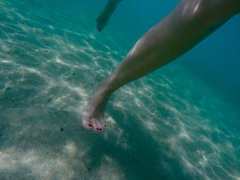 Low section of woman swimming in sea