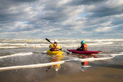 People in boat on sea against sky