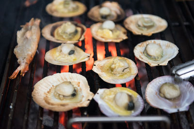 Scallop and shrimp with butter on pan grilled by charcoal fire. seafood barbecue or bbq