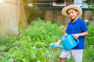 Portrait of smiling boy holding plants
