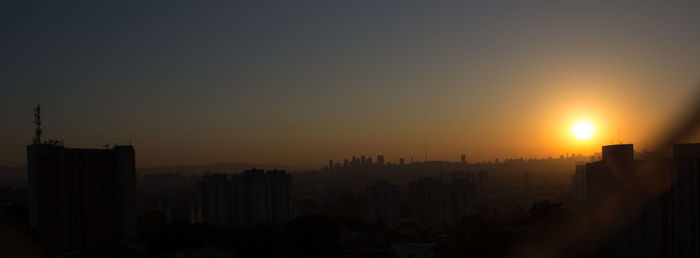 Silhouette cityscape against sky during sunset