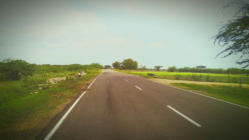 Road passing through landscape against clear sky