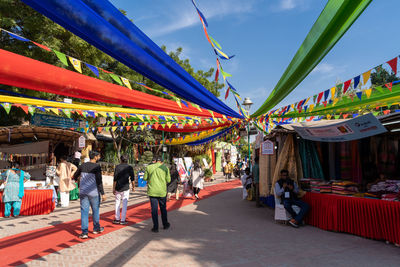 People in amusement park against sky in city