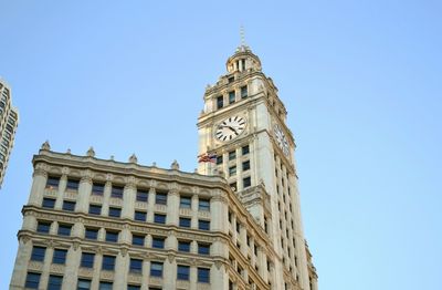 Low angle view of clock tower against blue sky
