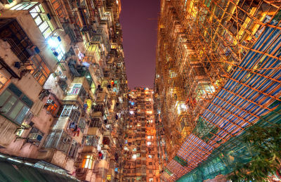 Low angle view of illuminated buildings against sky in city