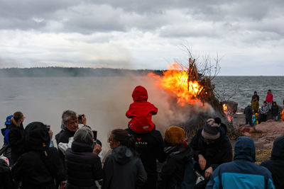 Group of people at beach against sky