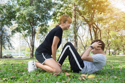 Side view of woman sitting on grass