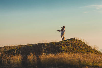 Man standing on field against sky