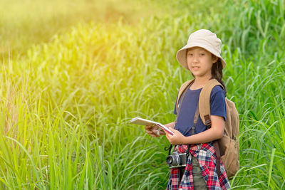Side view of a smiling girl standing on field