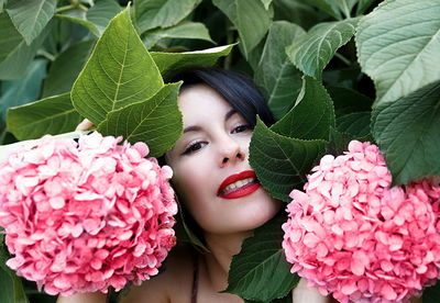 Close-up of woman with pink flowers and leaves