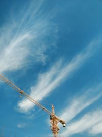 Low angle view of crane against blue sky