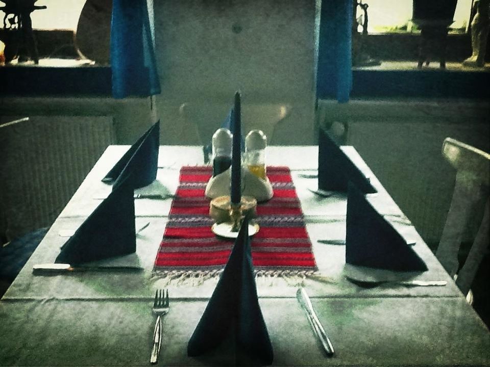 indoors, table, restaurant, red, chair, high angle view, incidental people, illuminated, empty, absence, no people, paper, communication, in a row, still life, day, sunlight, person, tiled floor