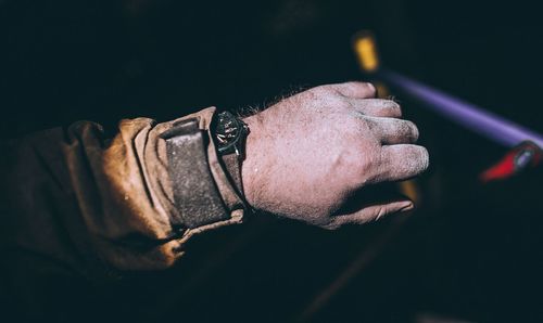 Cropped image of messy hand wearing wristwatch