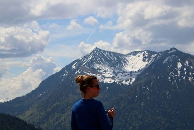 Woman standing against snowcapped mountain