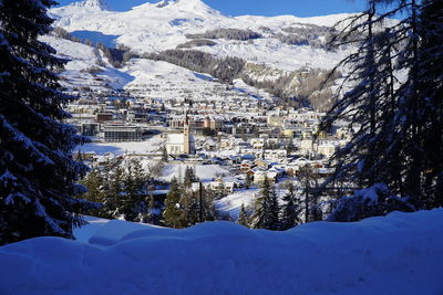 Snow covered buildings against mountain