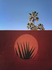 Plants drawn on brown wall against clear blue sky