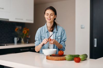 Portrait of smiling young woman using mobile phone at home