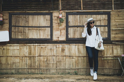 Woman in sunglasses standing against barn
