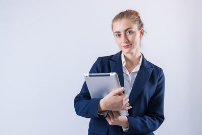 Portrait of a smiling young woman using smart phone against white background