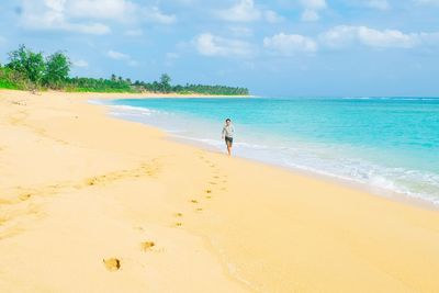 Man standing on beach against sky