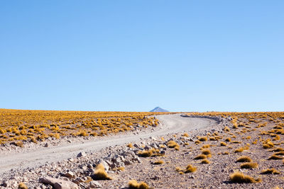 Scenic view of desert against clear blue sky