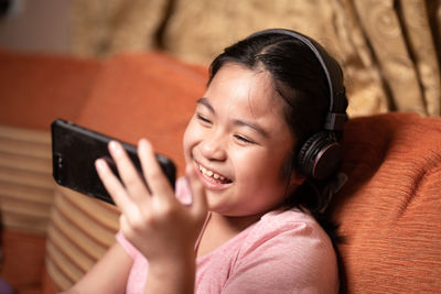 Portrait of smiling girl using mobile phone