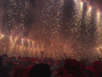 Crowd at music concert against sky at night