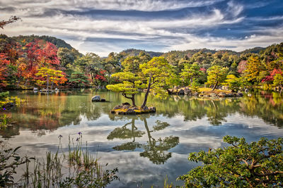 Scenic view of lake by autumn trees against sky