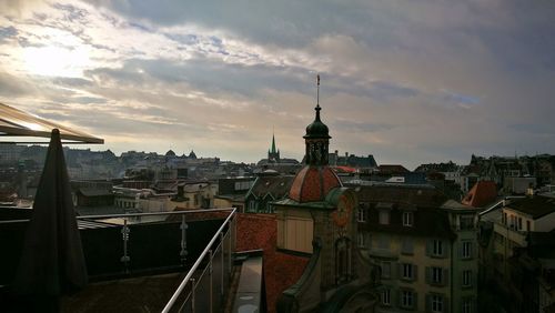 View of cityscape against cloudy sky