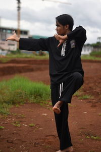 Young man practicing karate on field