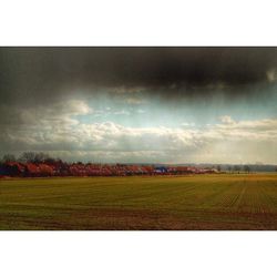 Scenic view of field against cloudy sky