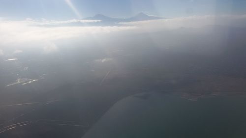 Aerial view of sea and mountains against sky