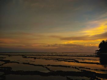 Scenic view of beach against sky during sunset