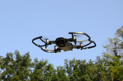 Low angle view of camera against blue sky