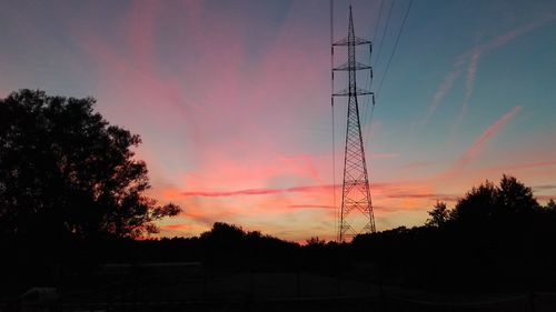 Silhouette of electricity pylon at sunset