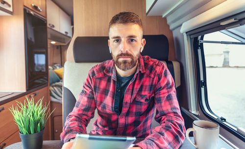 Portrait of man using digital tablet in motor home