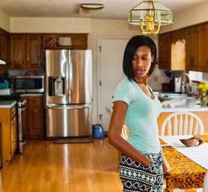 Portrait of smiling woman standing in kitchen