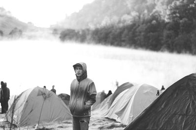 Man standing by tent on land