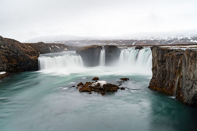 Scenic view of waterfall against sky