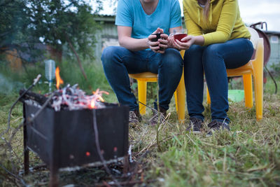 Low section of couple by barbecue